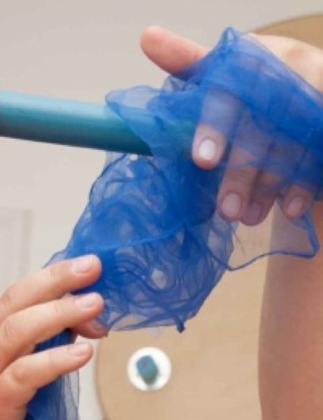 Kinderhand greift durch ein blaues Netz